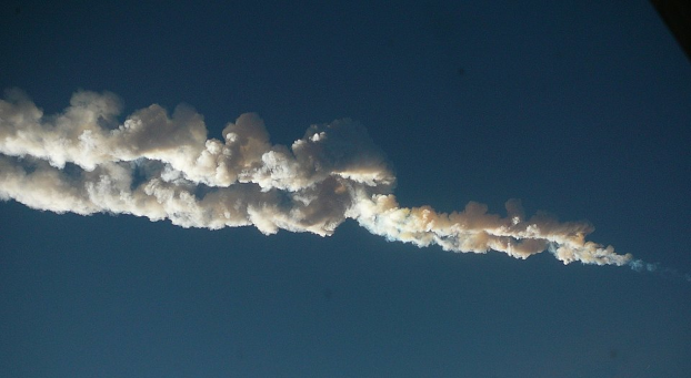 Photo, sur fond de ciel bleu, de la traînée laissée par le passage du météore de Tcheliabinsk en 2013, qui a causé pas mal de dégâts (mais n'a heureusement pas fait de victimes). On voit une quantité de fumée assez impressionnante, et pourtant ce bolide ne faisant qu'environ 12 000 tonnes, ce qui est minuscule par rapport aux comètes dont nous parlons ici.