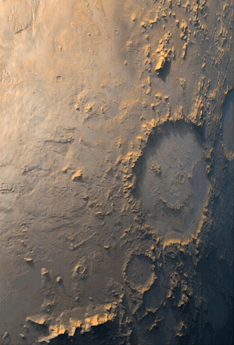 Puisqu'on en est à comparer, voici la photo du cratère Galle prise par la sonde Mars Global Surveyor le 13 octobre 1999. Cette fois-ci, on reconnaît immédiatement la même formation que sur l'image de Viking 1, avec le cratère circulaire, les deux yeux et le visage souriant, mais pour autant, il n'y a pas grand doute en regardant cette image, que ce n'est qu'une coïncidence, on peut d'ailleurs voir d'autres structures plus petites à l'intérieur du cratère.