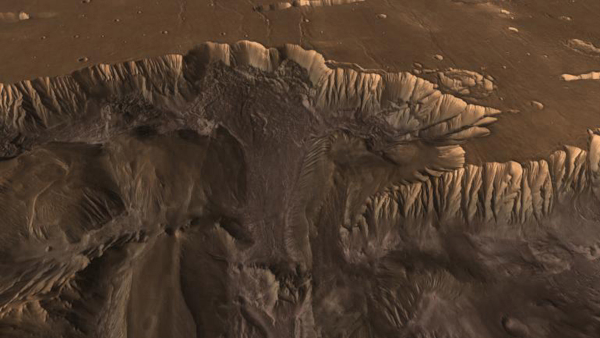 Vue aérienne de Valles Marineris, sans grand rapport avec ce qui précède mais parce que j'aime beaucoup l'endroit et que je n'aurai plus trop l'occasion d'en parler ici, ayant fait le tour de ce que ce que j'avais à vous dire d'intéressant sur Mars (enfin, il reste encore pas mal de trucs à creuser, mais a priori ce ne sera plus le sujet central d'un thread avant un moment). On voit donc, en haut de l'image, un plateau (assez plat malgré quelques cratères d'impact), et en bas, le relief (beaucoup plus tourmenté) d'une vallée. Entre les deux, des falaises assez gigantesques, même s'il est difficile d'estimer leur taille vu que la photo est prise de beaucoup plus haut. Avec les couleurs du sol, globalement marron, et ce relief particulier, l'endroit ressemble un peu au Grand Canyon sur Terre… à la différence près que Valles Marineris se trouvait aux USA comme le Grand Canyon, elle serait assez longue pour traverser le pays de la côte est à la côte ouest.