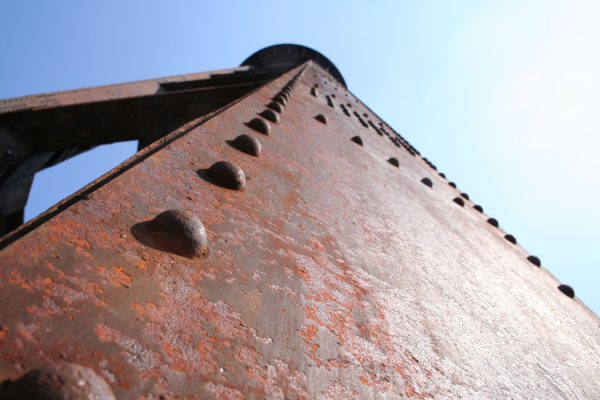 Photo, trouvée sur Wikimédia Commons, d'une structure de fer (en l'occurrence, il semble qu'il s'agisse de la tour d'un château d'eau, photographier de très près) en train de rouiller. On voit donc le ciel en haut, et sur la majeure partie de l'image, une surface de fer avec quelques rivets, le tout en grande partie envahi par la rouille. J'ai pris cette image en partie parce que je ne savais pas trop comment illustrer ce pouet, mais en fait, ça va me permettre de préciser deux choses : la rouille est une réaction d'oxydo-réduction comme celles dont il est question ici, mais cette famille de réactions est aussi très présente dans la chimie de la vie, on y reviendra sans doute dans un prochain thread. Mais surtout, la rouille est environ ce qui donne sa couleur à Mars : le sol de la planète contient une proportion assez importe d'oxyde de fer, et comme on peut le voir sur cette image, l'oxyde de fer est de couleur plutôt rouge-maronnasse, d'où le surnom de « planète rouge » de notre voisine.