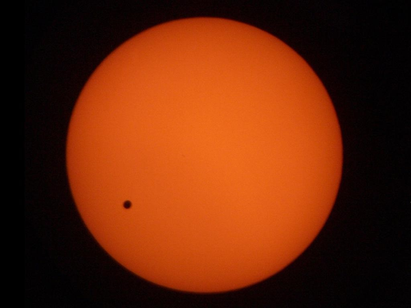 Photo prise (pas du tout par moi, je l'ai aussi trouvée sur Wikimédia Commons) lors du transit de Vénus de 2004. On voit le Soleil complet (toujours orange à cause du filtre solaire), et une petite tache qui passe à sa surface. Nettement plus grosse que celle de Mercure il y a quelques pouets, mais bien trop petite pour avoir le moindre effet visible sans instrument optique depuis notre planète.