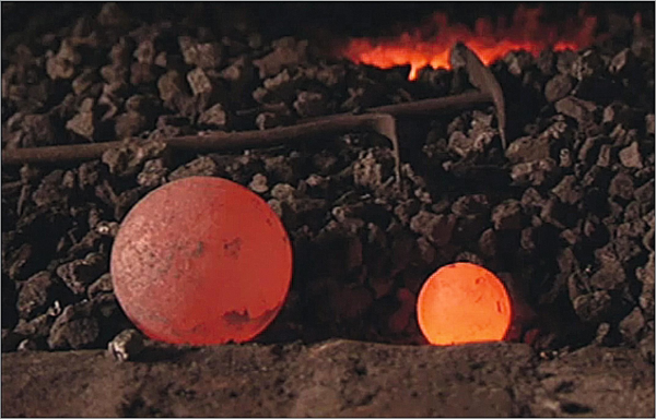 Image trouvée sur le net montrant deux boulets de canon chauffés au rouge posés sur un tas de charbon. La couleur indique qu'ils sont à une température différente, même si l'image n'est pas forcément si bien que ça puisque le plus petit des deux boulets est plus jaune/orange que l'autre, ce qui indiquerait donc qu'il est plus chaud, alors que plus une sphère est petite plus elle se refroidit vite. Mais bon, chercher mieux m'aurait pris plus de temps et je ne voulais pas publier ça trop tard non plus.