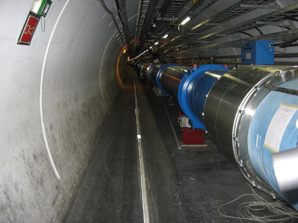 Photo du LHC (Large Hadron Collider, ou grand collisionneur de hadrons), le plus grand accélérateur de particules au monde actuellement. On voit globalement un grand tunnel avec un tube constitué de plusieurs parties, certaines visiblement métalliques et d'autres de divers tons de bleu.
