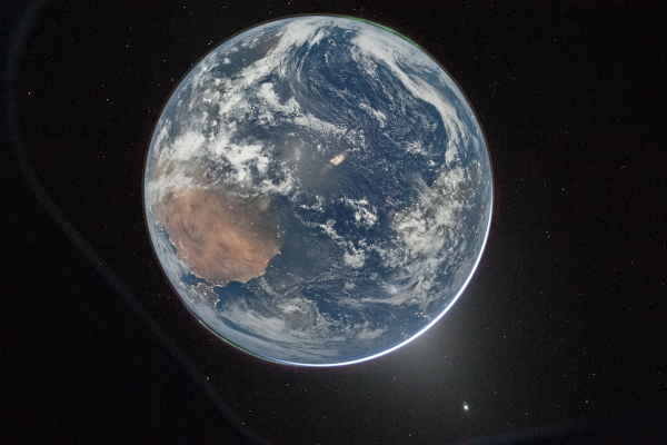 Photo de la Terre prise par l'équipage d'Artémis Ⅱ. On voit notre planète entière, avec ses océans et ses nuages, et une bonne partie du Sahara en bas à gauche, l'image étant orientée de telle sorte que le pôle nord soit en bas. On repère un reflet sur le hublot au milieu, quelques éclairages publics par endroit, et même deux aurores, une à chaque pôle. Le petit point lumineux en bas à droite est la planète Vénus vue dans le lointain. D'ailleurs, j'ai pas mal réduit l'image pour afficher ici, mais sur le cliché d'origine, le temps d'exposition permet même de voir quelques étoiles, souvent absentes quand on photographie de nuit un objet très lumineux. D'ailleurs, pour davantage de détails techniques au sujets de cette image, je vous renvoie à la vidéo de Defakator dont je parle dans le pouet suivant.