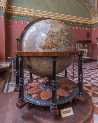 Image d'un globe terrestre dans un musée, trouvée sur Wikimédia Commons. On voit une sphère (tournée de sorte à ce qu'on voit le sud de l'Afrique et les océans qui l'entourent) posée sur un support permettant probablement de la faire tourner, mais avec une étiquette en bas invitant à ne pas toucher. Le tout est à l'intérieur d'un bâtiment et d'autres vitrines sont visibles en arrière-plan. À l'époque dont je parle dans le pouet (beaucoup plus ancienne que ce globe), on savait déjà que la Terre était globalement sphérique, mais on ignorait que ce que nous appelons « haut » et « bas » n'est dû qu'à la gravité terrestre (le « bas », c'est le centre de la Terre ; et le « haut » peut donc être dans n'importe quelle direction selon l'endroit où l'on se situe.)
