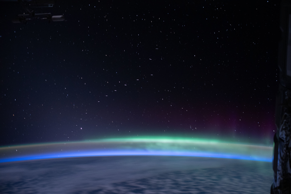 Et histoire de changer un peu de point de vue, voici un train de satellites de Starlink, puisque je ne vous avais pas de montré de photos plus haut, mais prise depuis la station spatiale internationale. On voit donc la Terre en bas, avec l'atmosphère dans lequel une lueur verte est probablement une aurore polaire, et on voit également sur les bords de l'image quelques parties de la station. Mais surtout, au milieu, sur le fond de ciel étoilé, une ligne de traits lumineux (ils ne sont pas tout à fait ponctuels ici à cause du mouvement rapide de la station) qui se détachent assez nettement.