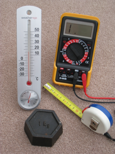 Photo (trouvée sur la page Wikipédia du système international) présentant quelques outils de mesure des unités usuelle : un thermomètre pour la température, un poids d'un kilogramme pour la masse, un mètre-ruban pour la longueur, et un multimètre électrique pour plusieurs choses dont on ne parlera pas dans ce thread, mais peut-être dans un prochain !