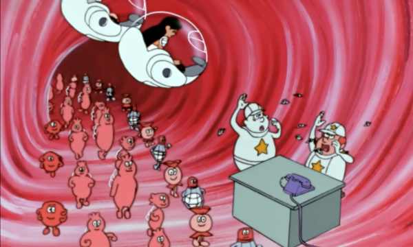 Autre capture du même dessin animé, montrant cette fois ce qui se passe à l'intérieur du corps humain. On voit un vaisseau sanguin dans lequel des globules rouges, nutriments et plaquettes sont en train de circuler, et sur le côté, une sorte de poste de contrôle où deux globules blancs sont attaqués par un groupe de ce qui ressemble à de petites mouches, ne sachant pas trop que faire pour s'en débarrasser. Un téléphone est posé sur une table, leur ayant servi à appeler du renfort : on voit Pierrot et Psi, les deux lymphocytes B habituels de la série, venir jeter un œil à la situation. Nous sommes ici dans le cas de l'enfant vacciné, aussi ces lymphocytes reconnaissent immédiatement l'envahisseur et produisent des anticorps spécifiques, ce qui permet de détruire les intrus avant même de tomber malade. Plus loin dans le même dessin animé, on voit le cas de l'enfant non-vacciné, où les anticorps produits n'ont aucun effet sur les toxines, qui se propagent donc davantage dans le corps, et la maladie se déclenche alors. Bien sûr, cet enfant sera heureusement guéri par l'injection de sérum antitétanique.