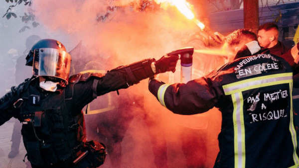 Photo de Yann Levy qui a pas mal circulé ces derniers temps sur le Fédivers. Prise lors d'une manifestation des sapeurs-pompiers pour réclamer plus de moyens en 2019, elle nous montre au premier plan un gendarme casqué et équipé en train de projeter à bout portant des gaz lacrymogènes au visage d'un pompier sur l'uniforme duquel est écrit « En colère » et « Pas un métier à risque ? », en référence à je-ne-sais-plus-quelle dinguerie qu'un membre de notre gouvernement avait dû balancer à l'époque. À l'arrière-plan, on devine quelques autres manifestants et membres des forces de l'ordre, mais la fumée nous masque la plupart de la scène. Si nous n'avons pas les moyens de faire face aux incendies de cet été, et plus généralement aux conséquences du dérèglement climatique, c'est totalement politique.