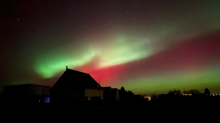 Autre photo prise par mon collègue ce soir-là, toujours à proximité de Lannion. On voit en bas la même maison plongée dans l'obscurité et quelques lampadaires lointains, mais la partie importante est de nouveau surtout le ciel nocturne où les quelques étoiles (on en voit plus que sur la photo précédentes) sont en partie masquées par magnifiques lueurs en trois couches, un vert bien lumineux, puis une partie rouge plus sombre, puis plus loin une autre bande verte au ton un peu différent de la première.
