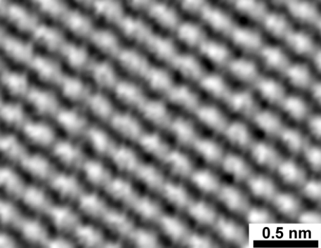 Photographie d'atomes de carbone de la surface d'un graphite, prises par un microscope à effet tunnel, une des formes de microscope à sonde locale (je suis assez loin de pouvoir entrer dans les détails). On voit globalement une série de creux et de bosses en noir et blanc, disposés très régulièrement, avec une échelle indiquant qu'on est en dessous de 0,5 nanomètres.