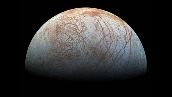 Photographie d'Europe prise par la sonde Juno en 2022. On voit une grosse boule principalement blanchâtre, mais avec des taches brunes (qui correspondent à des zones salées). On distingue également des striures, qui correspondent à ces gigantesques crevasses.