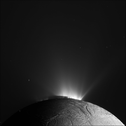 Autre photo d'Encelade prise par Cassini, celle-ci en noir et blanc. On ne voit que le haut de la lune, mais on y distingue clairement les geysers qui réfléchissent la lumière.