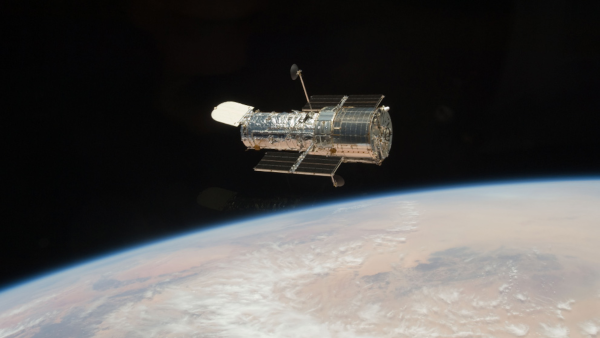 Photographie prise dans l'espace du télescope spatial Hubble, sur fond noir (la luminosité ne permet pas de voir les étoiles), avec une partie de la Terre visible en bas de l'image. L'image avait été utilisée en 2009 pour le calendrier de l'avent de Big Picture, sur le site du Boston Globe, qui présentait une photo astronomique par jour.