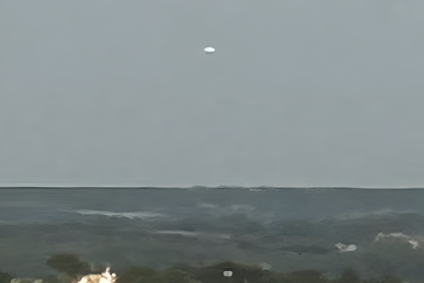 Photo trouvée sur le site du GEIPAN, prise le 18 juillet 2024 à Saint-Cast-Le-Guildo dans les Côtes-d'Armor. J'ai recadré un peu la photo, et surtout sélectionné la plus nette, le témoin en ayant pris quelques autres. On voit un paysage avec des arbres en contrebas, et plus haut, une sorte de petite tache blanche de forme ovale, qui ne ressemble pas franchement à un nuage et semble flotter dans le ciel. Le compte-rendu des enquêteurs présente les différentes pistes envisagées et les mesures faites pour déterminer la position de l'objet, qui s'avère ici être un avion de tourisme.