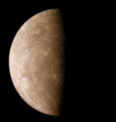 …et maintenant, une photo de Mercure prise par cette même sonde Mariner 10, trouvée sur Wikimédia Commons. On voit la planète en phase de quartier, donc avec seulement la moitié de la face visible éclairée. La photo est toujours prise dans les ultraviolets, mais post-traitée pour tenter d'approcher ce qu'on pourrait voir en vraies couleurs (si elle est grise vue de loin, Mercure doit apparaître plutôt brune comme ici vue de plus près. Un phénomène analogue a d'ailleurs été rapporté à propos de notre Lune). À noter que, si la rotation de Mercure sur elle-même dure environ 59 jours terrestres, le décalage dû à sa révolution fait que le jour et la nuit en durent chacun 88, soit la durée d'un tour complet de Mercure autour du Soleil.