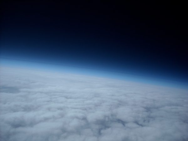 Photo de l'atmosphère terrestre (trouvée sur la page Wikipédia qui y est dédiée) prise au dessus des nuages : on voit donc en bas une étendue moutonneuse blanche, puis un dégradé de bleu indiquant la hauteur jusqu'à laquelle il reste suffisamment de matière pour continuer de renvoyer la lumière du Soleil, et sur toute la partie haute de l'image, le noir de l'espace. Bon, ici, il ne s'agit pas d'atteindre le vide spatial, mais de recréer du vide au niveau du sol, les deux demandant des technologies assez différentes ; mais donc, effectivement, si on monte au dessus de l'atmosphère, du vide, on en trouve assez facilement.